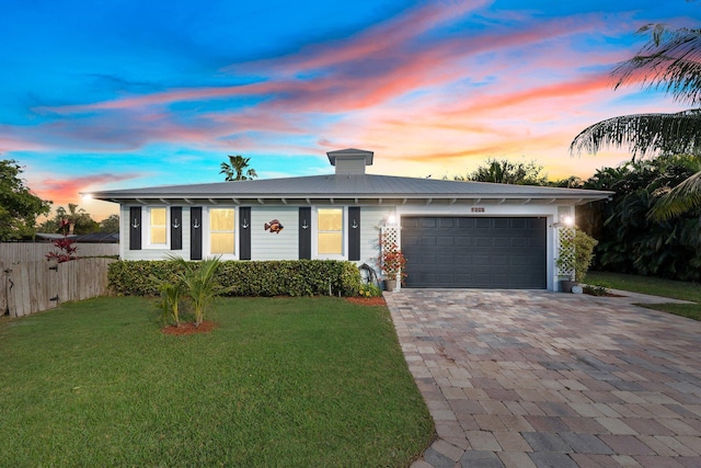 view of front facade with a garage and a yard