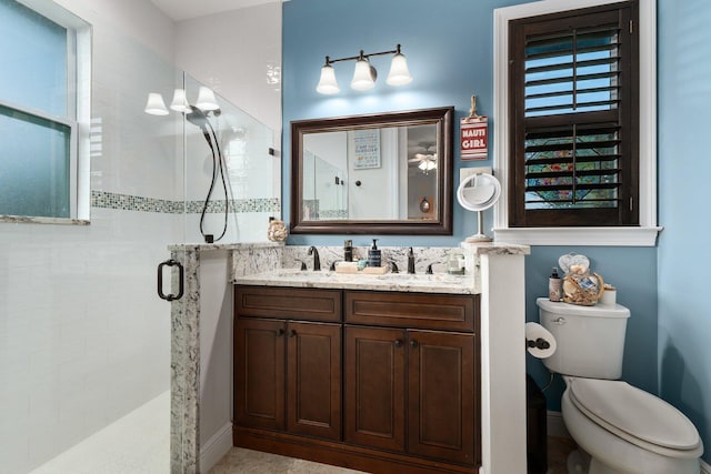 bathroom with a shower with door, vanity, and toilet