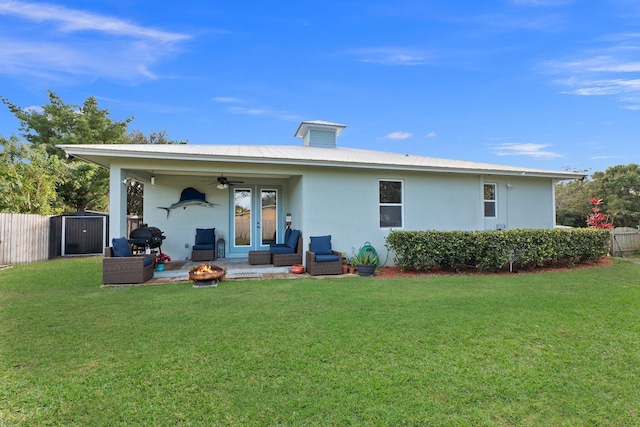 back of house featuring a lawn, outdoor lounge area, a storage shed, and a patio