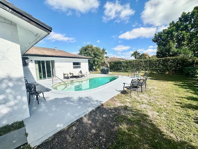 view of pool with a yard and a patio area