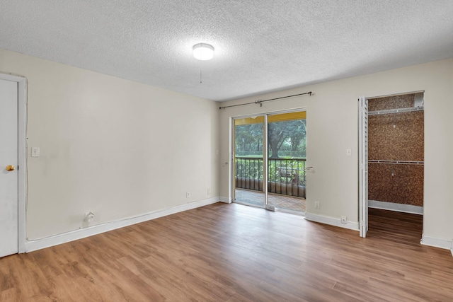 spare room with a textured ceiling and hardwood / wood-style flooring