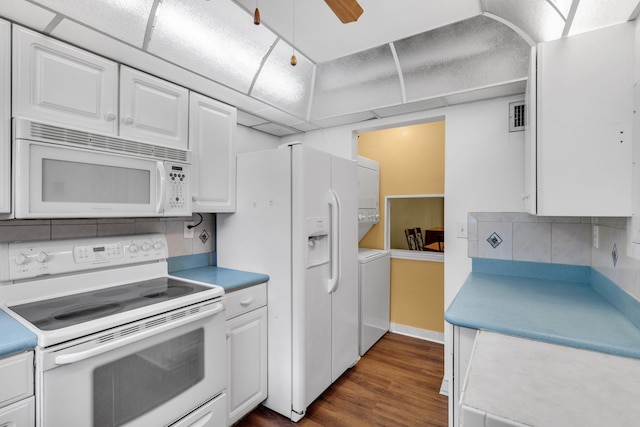 kitchen with decorative backsplash, white cabinetry, stacked washer and dryer, and white appliances