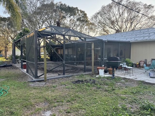 back of house with glass enclosure and a patio area