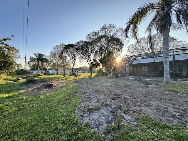 yard at dusk featuring glass enclosure