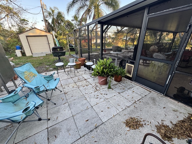 view of patio featuring glass enclosure and a shed