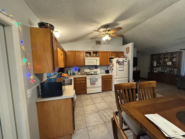 kitchen with lofted ceiling, white appliances, sink, ceiling fan, and light tile patterned flooring