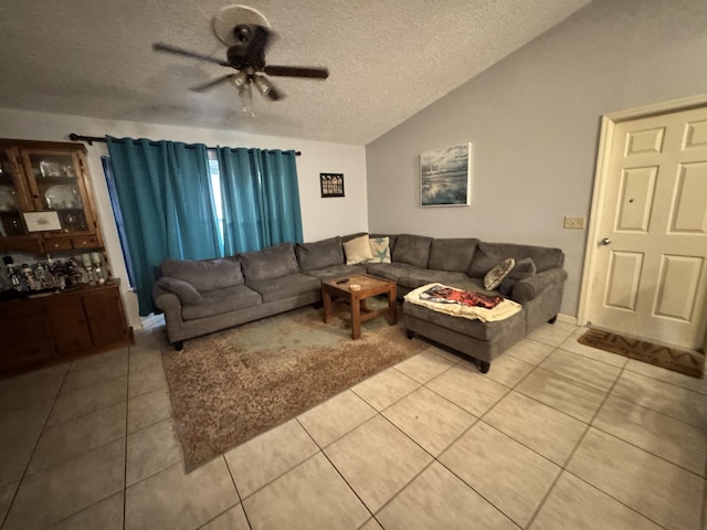 tiled living room with vaulted ceiling, ceiling fan, and a textured ceiling