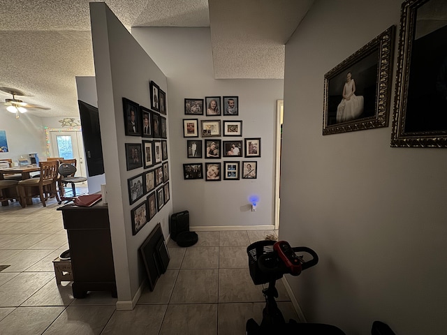 corridor featuring light tile patterned floors and a textured ceiling