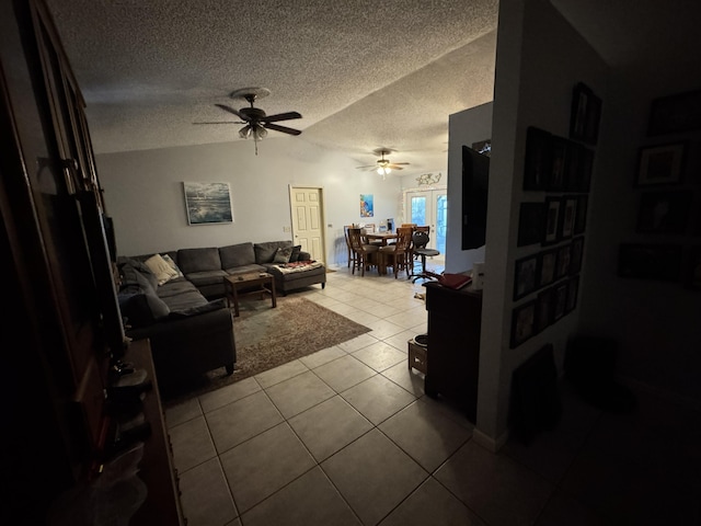 living room featuring light tile patterned floors, a textured ceiling, vaulted ceiling, and ceiling fan