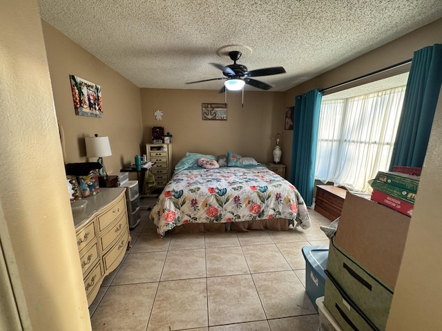 tiled bedroom with ceiling fan and a textured ceiling