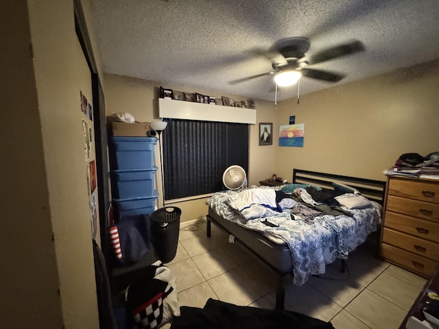 bedroom with a textured ceiling, ceiling fan, and light tile patterned flooring