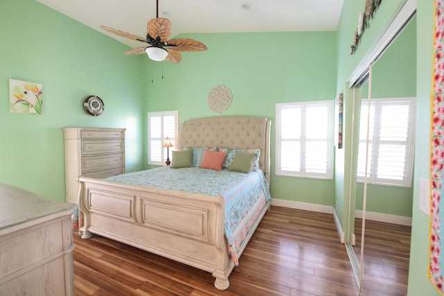 bedroom featuring a towering ceiling, ceiling fan, a closet, and multiple windows