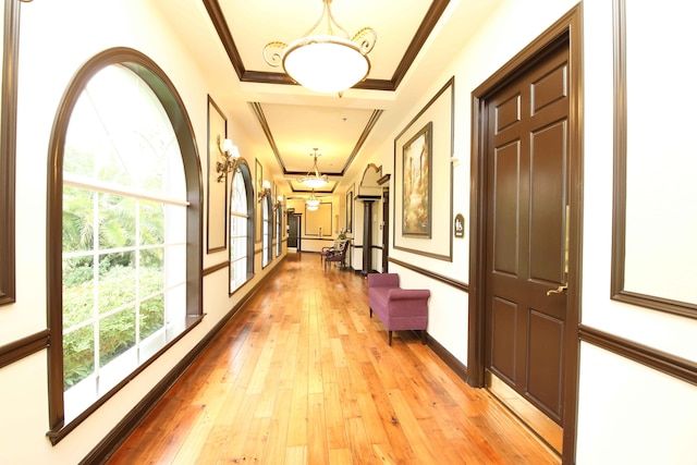 hall with light wood-type flooring and crown molding