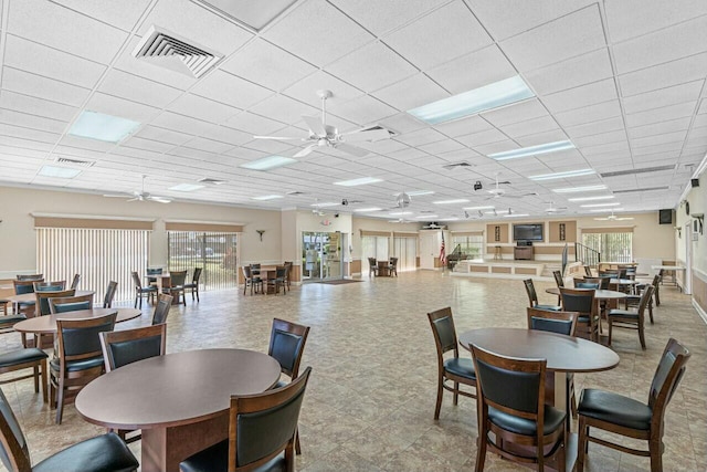 dining space featuring a drop ceiling and ceiling fan