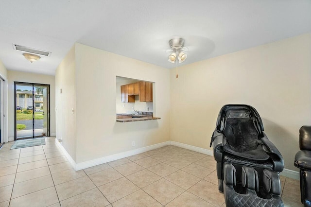 unfurnished office featuring ceiling fan, light tile patterned floors, and sink