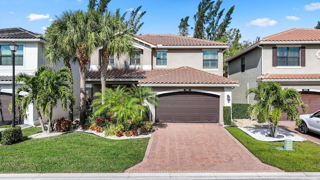 mediterranean / spanish-style home featuring a front yard and a garage