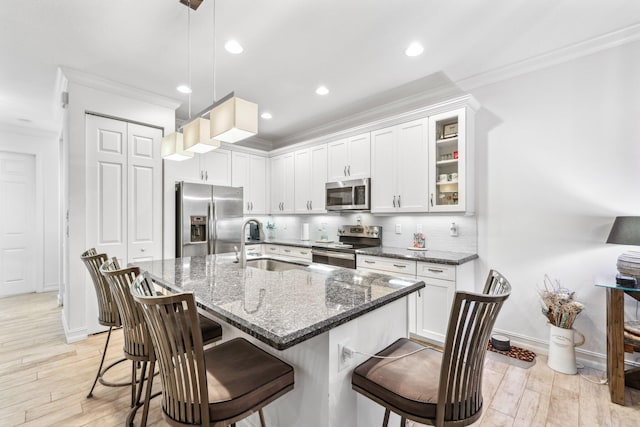 kitchen featuring stainless steel appliances, pendant lighting, a kitchen bar, and sink