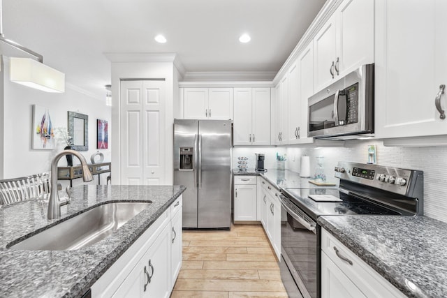 kitchen with stainless steel appliances, white cabinetry, and sink