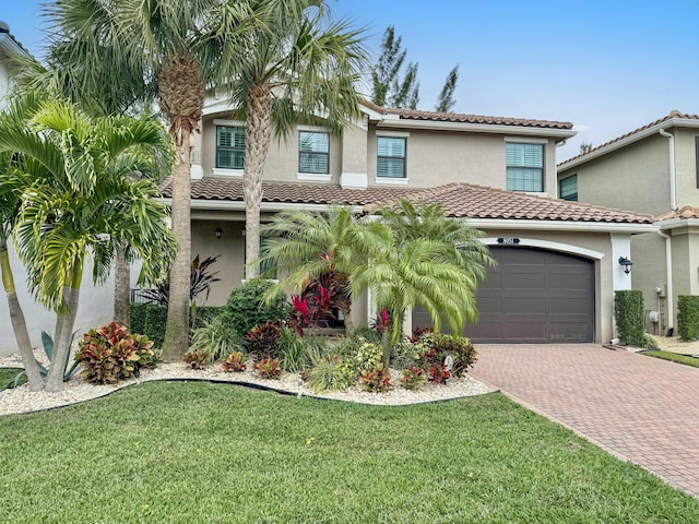 mediterranean / spanish-style house with a garage and a front lawn