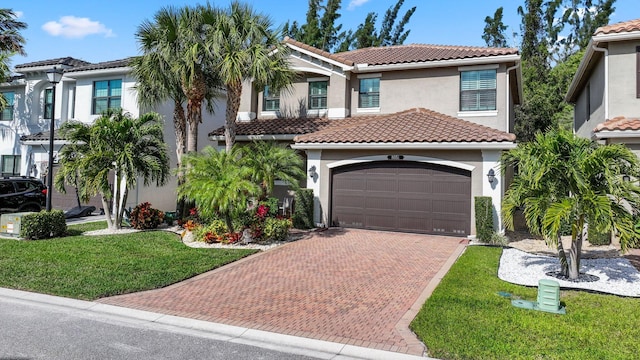 mediterranean / spanish house with a front lawn and a garage