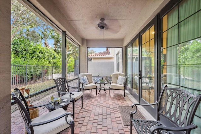 sunroom / solarium featuring ceiling fan