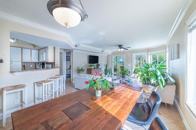 dining room featuring light tile patterned flooring, ceiling fan, and crown molding