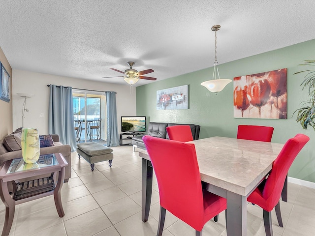 dining space featuring a textured ceiling, ceiling fan, and light tile patterned floors