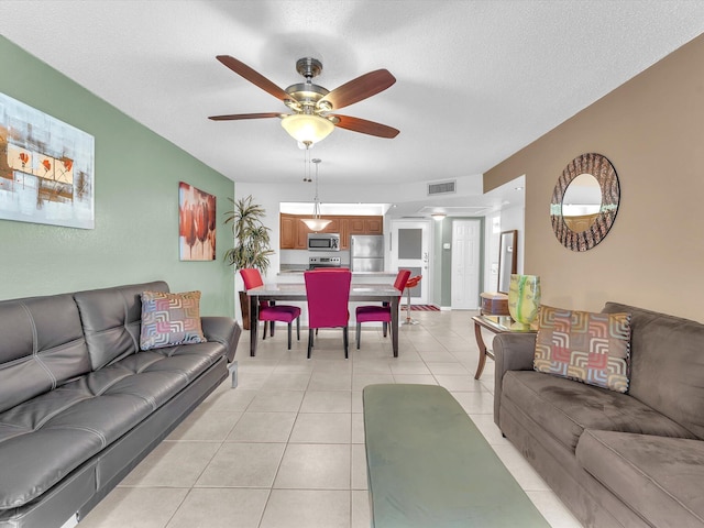 tiled living room featuring a textured ceiling and ceiling fan