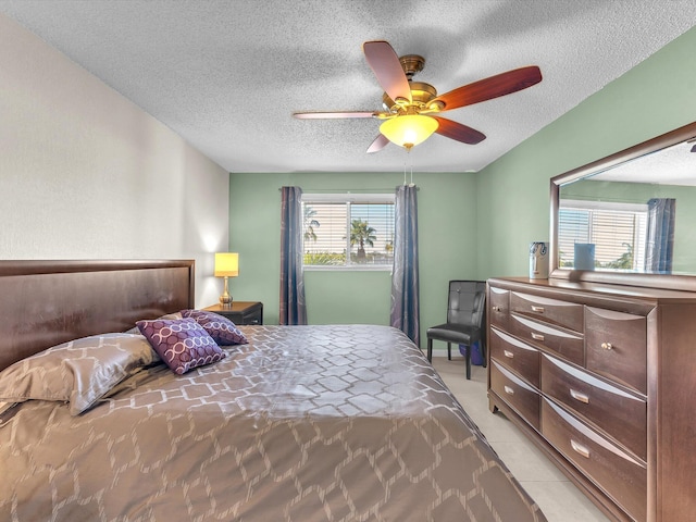 tiled bedroom featuring ceiling fan and a textured ceiling