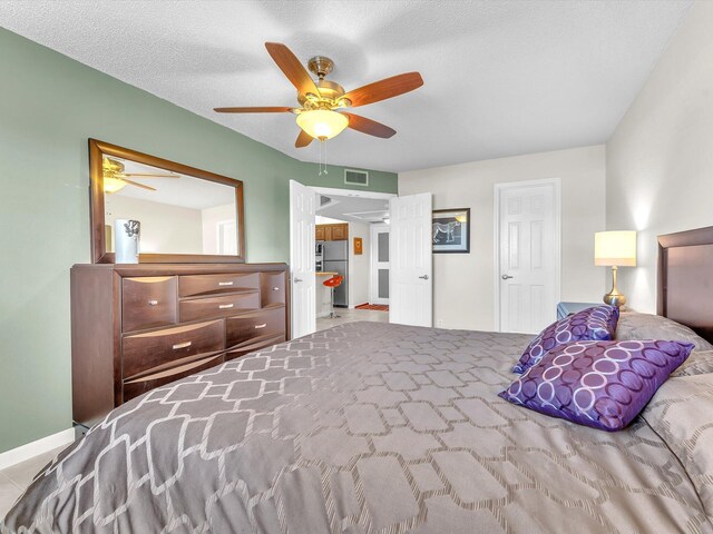 bedroom with ceiling fan and a textured ceiling