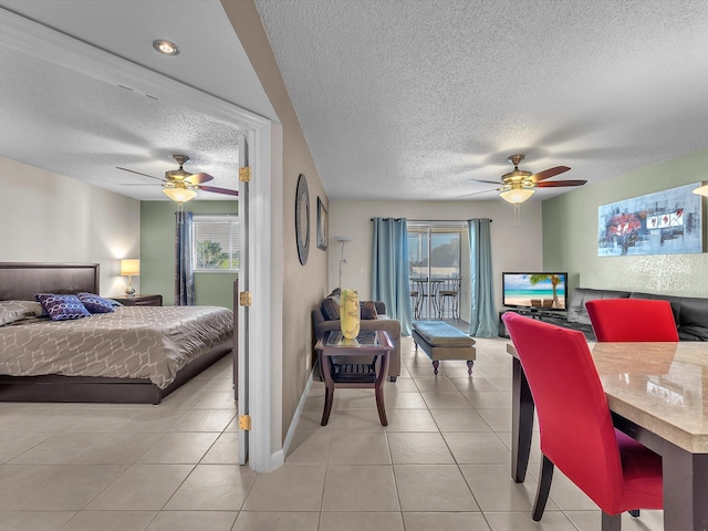 tiled bedroom featuring a textured ceiling, ceiling fan, access to outside, and multiple windows