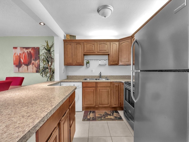 kitchen with light tile patterned floors, appliances with stainless steel finishes, and sink