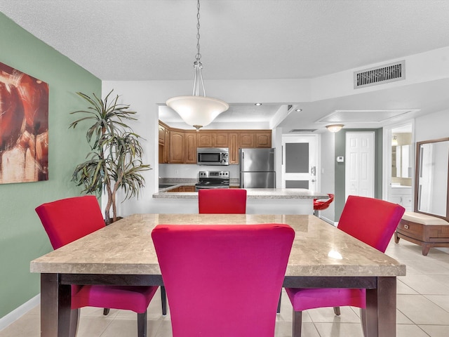 dining room with a textured ceiling and light tile patterned floors