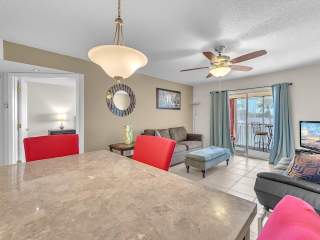 interior space featuring ceiling fan, a textured ceiling, and light tile patterned floors