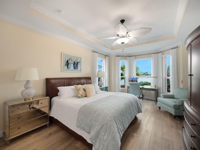 bedroom featuring hardwood / wood-style flooring, a raised ceiling, and ceiling fan