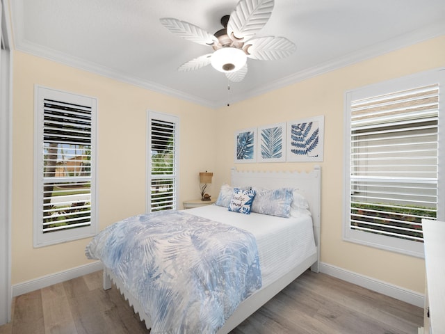 bedroom featuring crown molding, light hardwood / wood-style floors, and ceiling fan