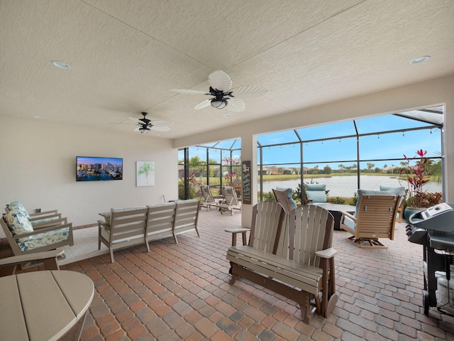 view of patio / terrace with an outdoor living space, ceiling fan, and glass enclosure