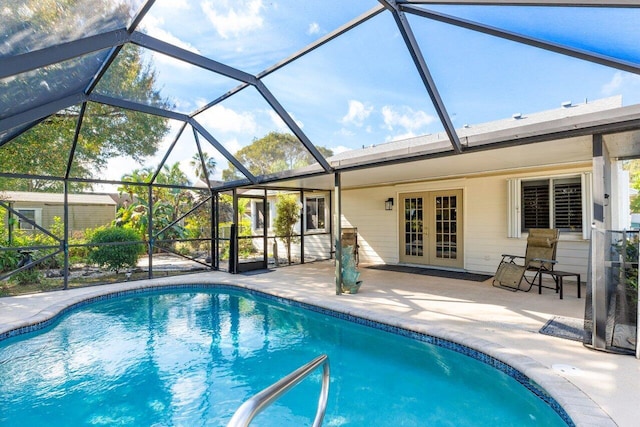 view of swimming pool with a lanai, a patio area, and french doors