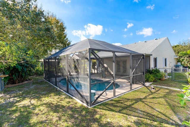 view of pool featuring french doors, a patio, a lanai, and a lawn