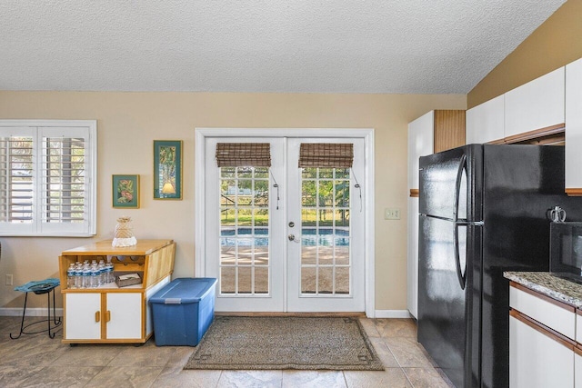 doorway featuring french doors, a textured ceiling, and lofted ceiling