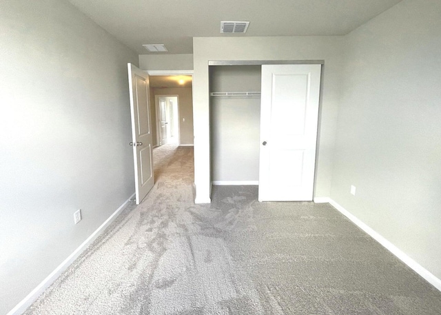 unfurnished bedroom featuring a closet and light colored carpet