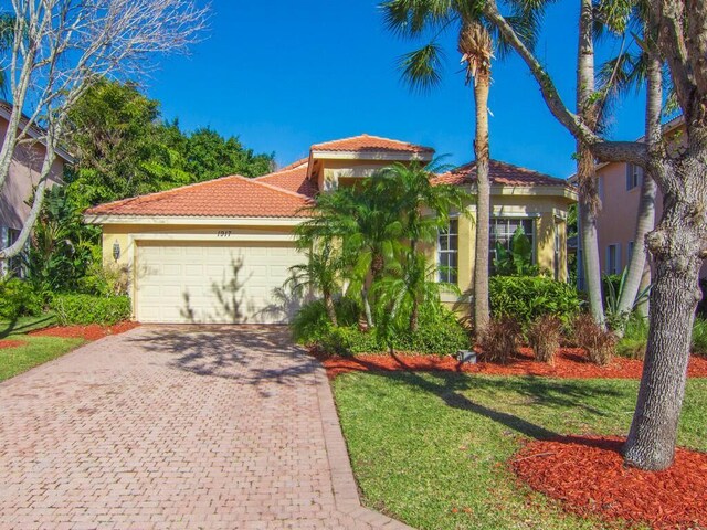 mediterranean / spanish-style home featuring a front yard and a garage