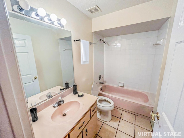 full bathroom featuring vanity, tile patterned flooring, tiled shower / bath combo, toilet, and a textured ceiling