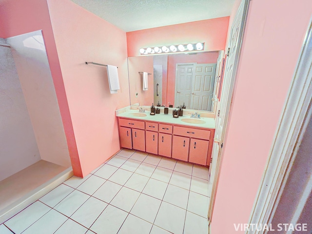 bathroom featuring tile patterned flooring, vanity, and a textured ceiling