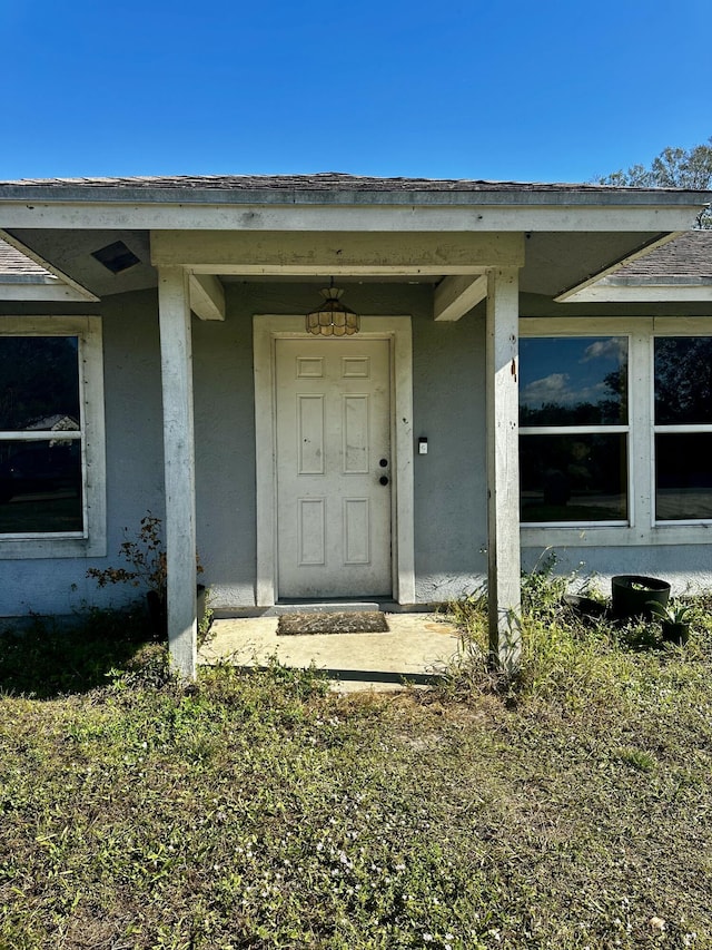 property entrance with stucco siding