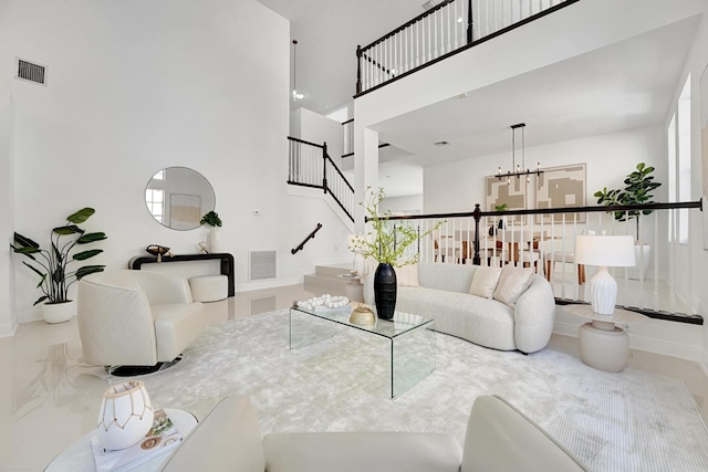 living room featuring a towering ceiling and a notable chandelier