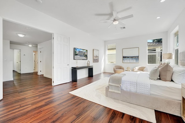 bedroom featuring multiple windows, dark wood-type flooring, and ceiling fan