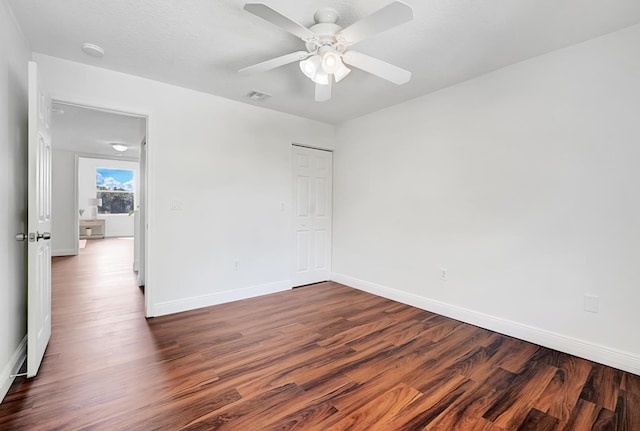 empty room with dark hardwood / wood-style flooring, a textured ceiling, and ceiling fan