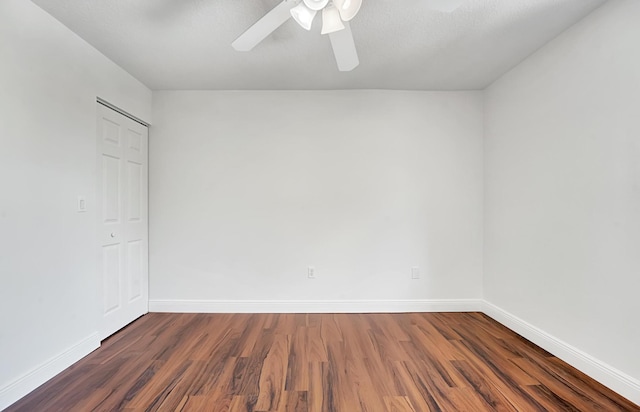 empty room with ceiling fan and dark hardwood / wood-style flooring