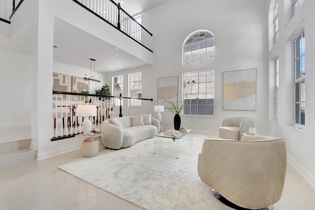 tiled living room featuring a notable chandelier and a high ceiling